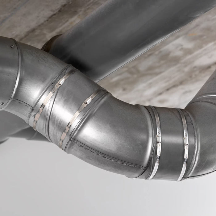Mechanic tightening dryer hose and clamp worm gear band on engine piping, showing installation with a socket driver.