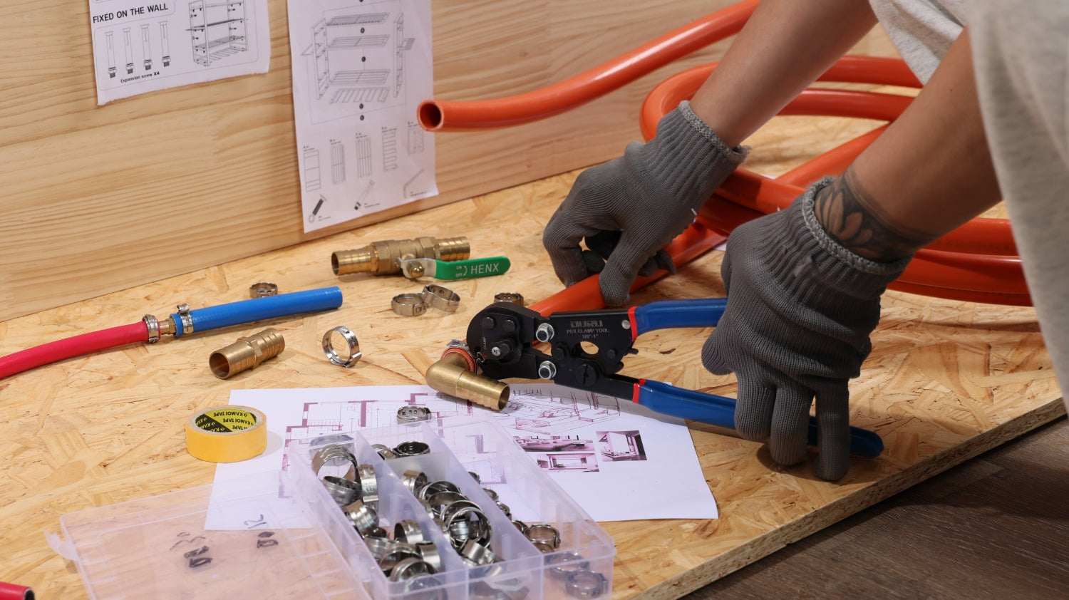 Hand cutting and crimping orange tubing with a compact pex crimp and cut tool for clean, accurate plumbing installs.